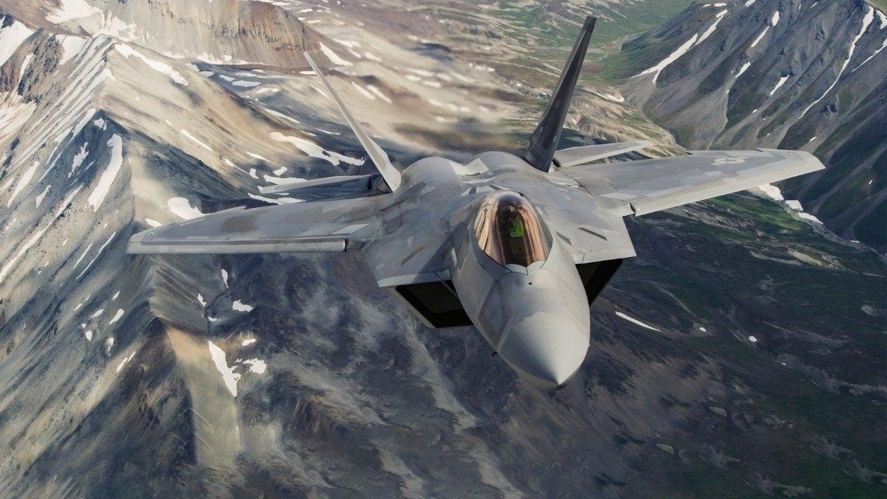 F-22 Raptor banking over mountains