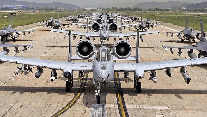 Military jets lined up on a runway